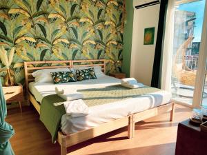 a bedroom with a bed with a tropical wallpaper at Finestra sulla Sicilia in Catania