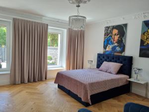 a bedroom with a bed and a painting on the wall at Oliwa Am Calsberg 5a in Gdańsk