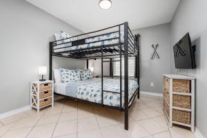 a bedroom with a bunk bed and a tv at Private Beach Access, Fenced Yard & Pet Friendly, Cabana Life Beach House in Destin