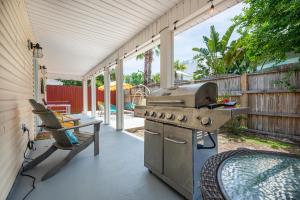 a patio with a grill and a table and a chair at Private Beach Access, Fenced Yard & Pet Friendly, Cabana Life Beach House in Destin
