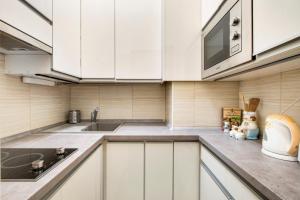a kitchen with white cabinets and a sink at Károlyi street - central location quiet place 2ppl in Budapest