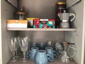 a cupboard with wine glasses and dishes on a shelf at Music House - Carozzi Apartments in Milan