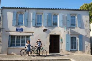 twee personen met fietsen voor een gebouw bij Logis des Lauriers Roses in Marennes