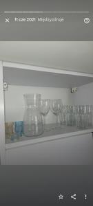 a shelf with wine glasses sitting on it at Apartament Magnolia przy morzu in Międzyzdroje