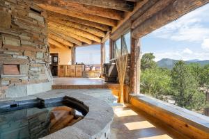 an outdoor swimming pool in a stone building with a large window at Earthship retreat + 2 spas + incredible views. in Santa Fe
