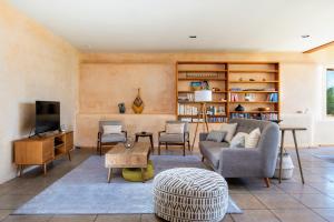 sala de estar con sofá y mesa en Earthship retreat + 2 spas + incredible views., en Santa Fe