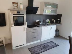 una cucina con mobili bianchi e un lavandino di ***FeWo Am Achterwasser *** a Lütow