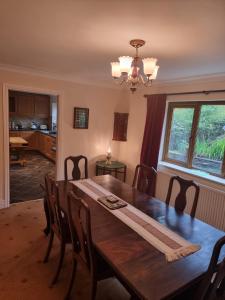 a dining room with a wooden table and chairs at Criccieth Family holiday house in Morfa Bychan