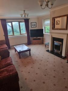 a living room with a couch and a fireplace at Criccieth Family holiday house in Morfa Bychan