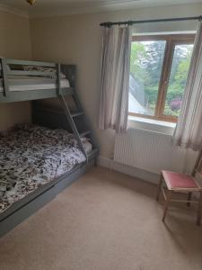 ein Schlafzimmer mit zwei Etagenbetten und einem Fenster in der Unterkunft Criccieth Family holiday house in Tremadoc