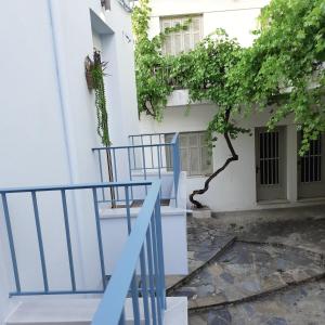 un edificio blanco con barandilla azul y escalera en Central apartment, en Patitiri