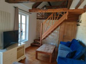 sala de estar con sofá azul y escalera en Le Delax en Mondeville