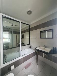 a bathroom with a tub and a sink and a mirror at Langholm Hotel in Walvis Bay +59 photos