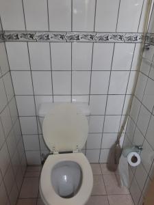 uma casa de banho com WC num quarto com azulejos brancos em Complejo las Palmeras em Godoy Cruz