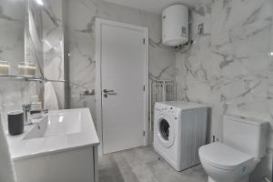 ein weißes Bad mit einer Waschmaschine in der Unterkunft Malibú Canteras nº 1 - Planta Baja - Ground Floor in Las Palmas de Gran Canaria + 23 Fotos