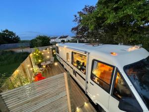 un wagon garé au-dessus d'une terrasse en bois dans l'établissement Vintage 1980s Winnebago, à Oxford