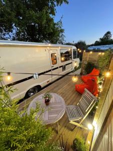 una cabaña estacionada en una terraza con una silla y una mesa en Vintage 1980s Winnebago, en Oxford