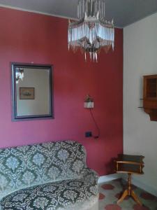 1 dormitorio con cama y lámpara de araña en La Séca - Antico Albergo Alzese en Pella