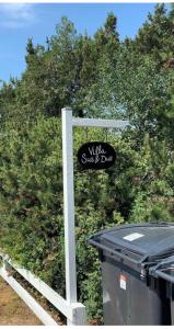 een bord voor een wijnwinkel en een vuilnisbak bij Villa Sus & Dus in Yngsjö