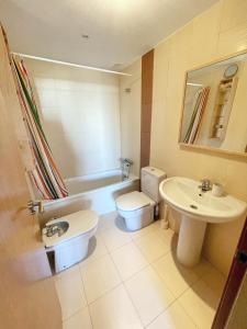 een badkamer met een toilet, een wastafel en een bad bij Amplio apartamento en La Cala in Cala de Finestrat