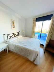 een slaapkamer met een bed en een groot raam bij Amplio apartamento en La Cala in Cala de Finestrat
