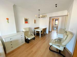 een woonkamer met een bureau, stoelen en een tafel bij Amplio apartamento en La Cala in Cala de Finestrat