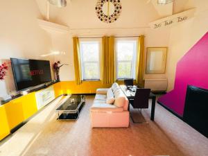 a living room with a couch and a tv at PHOENIX Apartments in Goole