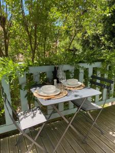 una mesa con platos y vasos en una cubierta en villa blanche Cabine 1, en Cap-Ferret