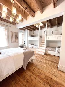 - une chambre avec un grand lit et du parquet dans l'établissement La Demeure du Capitaine, à Neuville