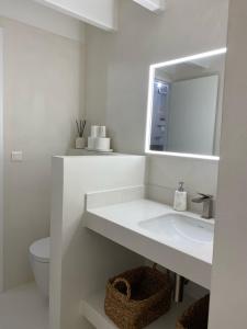 a white bathroom with a sink and a mirror at villa blanche Cabine 1 in Cap-Ferret