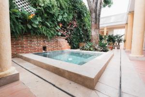 una piscina en un patio con una pared de ladrillo en Casa Jaguar Hotel Boutique, en Cartagena de Indias