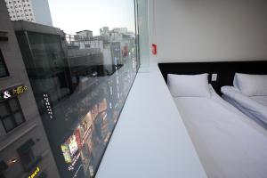 Rúm í herbergi á Ekonomy Hotel Myeongdong Premier