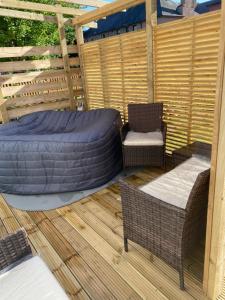 a covered patio with a bed and a chair at Lovely 3 bed with jacuzzi, close to airport, driveway, wifi in Edinburgh