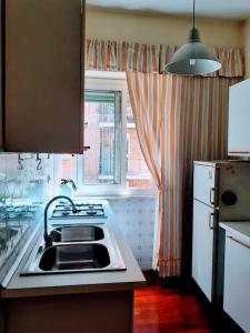une cuisine avec un évier et une fenêtre dans l'établissement Casa Rosi, à Rome