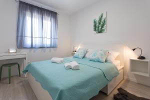 a bedroom with a bed with towels on it at Delminium in Kaštela