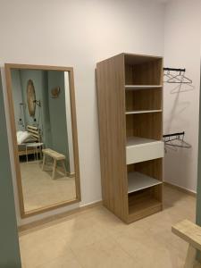 a wooden book shelf next to a mirror in a room at Estudio canela in Melilla