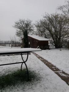 un banco cubierto de nieve frente a un granero en chambres d hotes ,hotel ,Secret d'une Nuit a vicq prės de valenciennes,onnaing,saint saulve avec piscine , jaccuzi, en Valenciennes