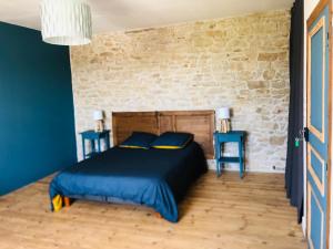 a bedroom with a bed with blue sheets and two blue tables at La Plooz - Chambres, Dortoirs & Océan in Plozévet