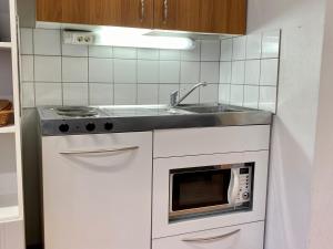 a kitchen with a sink and a microwave at City Apartment Kuopio in Kuopio