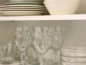 a row of wine glasses sitting on a shelf at City Apartment Kuopio in Kuopio