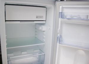 an empty refrigerator with its door open at ESTUDIO BOCINEGRO in Conil de la Frontera