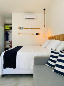 een slaapkamer met een wit bed en een bank bij Meditarranee Residence in Camocim
