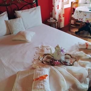 a white bed with a tea set on it at Dimitra House in Mithymna