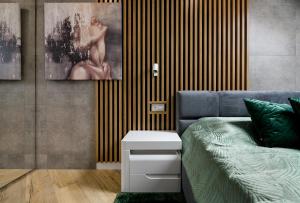 1 dormitorio con 1 cama y una pintura en la pared en Apartamenty Magia Bałtyku en Darłowo