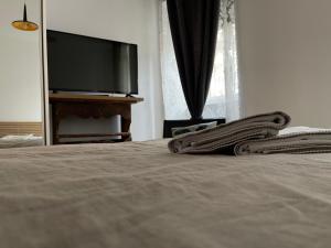 een slaapkamer met een bed en een flatscreen-tv bij Apartments Kremenic in Cres