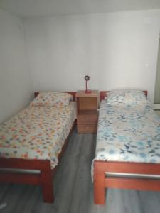 two twin beds in a room with a dresser at Milica studio,Skradinsko polje 24 in Skradin