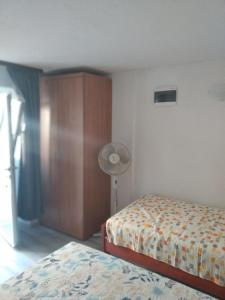 a bedroom with two beds and a lamp and a fan at Milica studio,Skradinsko polje 24 in Skradin