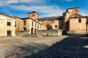 a large brick building with a stone courtyard at Hostería Miguel Angel in Santillana del Mar