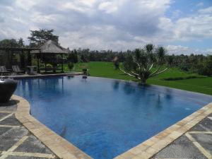 a large blue swimming pool with a gazebo at Bumi Ubud Resort in Ubud