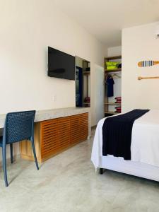 Meditarranee Residence في كاموسين: غرفة نوم بسرير ومكتب مع تلفزيون